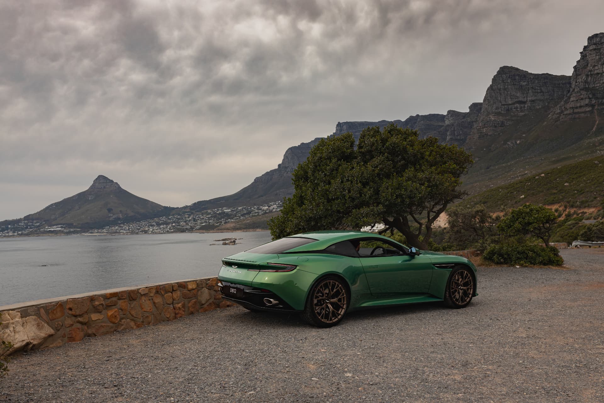 Green DB12 parked above the Atlantic with the Twelve Apostles mountains behind
