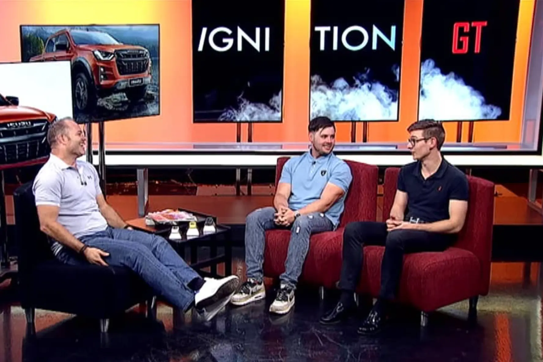 Three presenters seated in the Ignition GT television studio during an automotive discussion